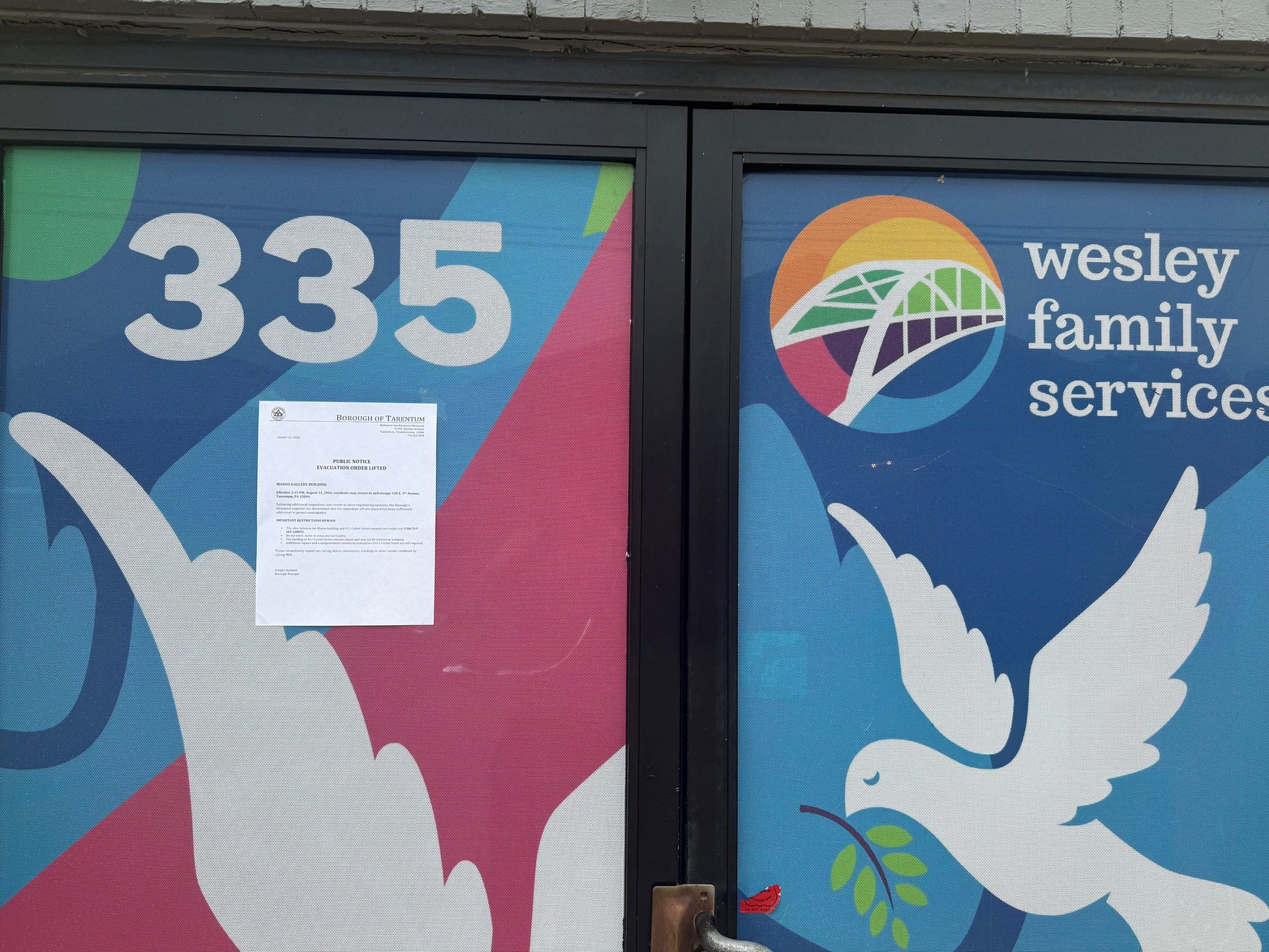 Public notice posted lifting the evacuation order for the Manos Gallery building, August 11